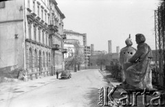 Lata 50. lub 60., Warszawa, Polska.
Ulica Aleksandra Fredry – widok w kierunku północno-wschodnim. Rzeźby Adama Mickiewicza i Mikołaja Kopernika (z prawej). Od lewej kolejno budynki na ulicy Aleksandra Fredry 8 i 6, dalej Teatr Wielki i blok przy ulicy Moliera 2/4/6.
Fot. NN, kolekcja Ireny Jarosińskiej, zbiory Ośrodka KARTA