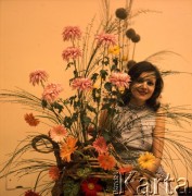 Lata 60. lub 70., Polska.
Modelka wśród kwiatów.
Fot. Irena Jarosińska, zbiory Ośrodka KARTA
