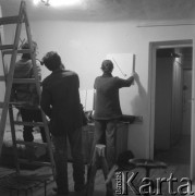 styczeń 1983, Warszawa, Polska.
Przygotowania do wernisażu w pracowni Ireny Jarosińskiej. Na zdjęciu m.in. Koji Komoji (na pierwszym planie, przy drabinie), jego żona (na drabinie) i Włodzimierz Borowski (wiesza obraz).
Fot. Irena Małek-Jarosińska, zbiory Ośrodka KARTA.