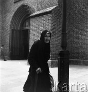 Lata 50. lub 60., Warszawa, Polska.
Kobieta pod Bazyliką Archikatedralną św. Jana Chrzciciela.
Fot. Irena Jarosińska, zbiory Ośrodka KARTA