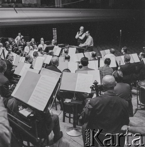1965, Warszawa, Polska.
Międzynarodowy Festiwal Muzyki Współczesnej „Warszawska Jesień”. Włoski kompozytor Luigi Nono (siedzi przed orkiestrą) z dyrygentem Andrzejem Markowskim (obok Nono) w Filharmonii Narodowej.
Fot. Irena Jarosińska, zbiory Ośrodka KARTA