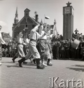 1.05.1954, Starogard Gdański, Polska
Pochód pierwszomajowy - przez starogardzki rynek przechodzą dzieci w strojach ludowych.
Fot. Irena Jarosińska, zbiory Ośrodka KARTA