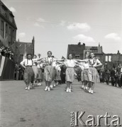 1.05.1954, Starogard Gdański, Polska
Pochód pierwszomajowy - przez starogardzki rynek przechodzą dziewczynki w strojach ludowych.
Fot. Irena Jarosińska, zbiory Ośrodka KARTA