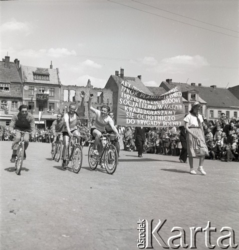 1.05.1954, Starogard Gdański, Polska
Kolarze w pochodzie pierwszomajowym, obok widoczny transparent z napisem: „Aby móc realizować IV rok planu 6 letniego i przyśpieszyć budowę socjalizmu w naszym kraju zgłaszamy się ochotniczo do brygady rolnej”.
Fot. Irena Jarosińska, zbiory Ośrodka KARTA