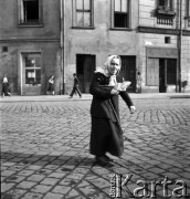 lata 50-te, Kraków, Polska
Staruszka na Rynku Starego Miasta. W głębi widać restaurację Wierzynek.
Fot. Irena Jarosińska, zbiory Ośrodka KARTA