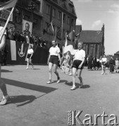 1.05.1954, Starogard Gdański, Polska
Pochód pierwszomajowy - dziewczęta przechodzą przy trybunie honorowej. W głębi, na fasadzie budynku portret premiera ZSRR Nikołaja Bułganina
Fot. Irena Jarosińska, zbiory Ośrodka KARTA