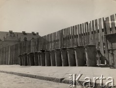 lata 50-te, Warszawa, Polska.
Rząd metalowych śmietników ustawionych przy płocie, w głębi Pałac Biskupów Krakowskich przy ul. Miodowej.
Fot. Irena Jarosińska, zbiory Ośrodka KARTA.