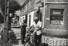 lata 50-te, Polska.
Przechodnie na ulicy. Za nimi sklep z pieczywem.
Fot. Irena Jarosińska, zbiory Ośrodka KARTA.