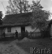 Lata 50., Polska.
Członkowie Ochotniczej Straży Pożarnej przed wejściem do domu. 
Fot. Irena Jarosińska, zbiory Ośrodka KARTA