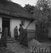 Lata 50., Polska.
Członkowie Ochotniczej Straży Pożarnej rozmawiają z kobietą przed wejściem do domu. 
Fot. Irena Jarosińska, zbiory Ośrodka KARTA