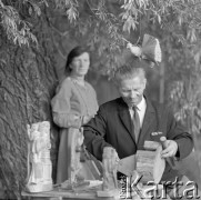 1970, Stara Wieś, woj. lubelskie, Polska.
Rzeźbiarz ludowy Feliks Dutkiewicz podczas pracy nad rzeźbą. W tle stoi kobieta.
Fot. Irena Jarosińska, zbiory Ośrodka KARTA