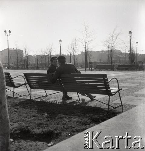 Lata 50., Warszawa, Polska.
Przed Pałacem Kultury i Nauki. Mężczyźni siedzą na ławce. 
Fot. Irena Jarosińska, zbiory Ośrodka KARTA