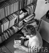 1970, Warszawa, Polska.
Ewa Długosz, urodzona w obozie koncentracyjnym Ravensbruck, n/z w mieszkaniu, z tomikiem poezji obozowej 