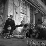 1964, Warszawa, Polska.
Zakład Budowy Urządzeń Przemysłowych. Amerykański piosenkarz Pete Seeger (w jasnym swetrze) w otoczeniu dzieci i młodzieży. 
Fot. Irena Jarosińska, zbiory Ośrodka KARTA