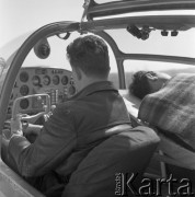 1960-1965, Katowice, woj. śląskie, Polska.
Pilot sanitarny Edward Makula (1930-1996) z Zespołu Lotnictwa Sanitarnego przy Wojskowej Stacji Pogotowia Ratunkowego w samolocie Aero Ae-145, obok leży pacjent.
Fot. Irena Jarosińska, zbiory Ośrodka KARTA
