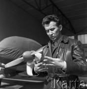 1960-1965, Katowice, woj. śląskie, Polska.
Pilot sanitarny w Zespole Lotnictwa Sanitarnego przy Wojskowej Stacji Pogotowia Ratunkowego Edward Makula (1930-1996) stoi przed hangarem dla samolotów. Za nim widoczny samolot Aero Ae-145.
Fot. Irena Jarosińska, zbiory Ośrodka KARTA
