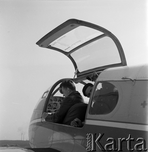 1960-1965, Katowice, woj. śląskie, Polska.
Wojskowa Stacja Pogotowia Ratunkowego. Pilot sanitarny w Zespole Lotnictwa Sanitarnego Edward Makula (przy sterach) sprawdza z mechanikiem samolot Aero Ae-145. 
Fot. Irena Jarosińska, zbiory Ośrodka KARTA
