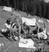 Lata 60., Polska.
Grupa osób w obozie taternickim w górach. 2. z lewej siedzi taternik Adam Szurek, 3. ratownik tatrzański i przewodnik Józef Uznański.
Fot. Irena Jarosińska, zbiory Ośrodka KARTA