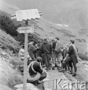 4.-5.06.1964, Tatry, Polska.
Angielski alpinista i kierownik zdobywczej wyprawy na Mount Everest w 1953 r. sir John Hunt (stoi przodem w kraciastej koszuli) rozmawia z Janem Józefem Szczepańskim z Klubu Wysokogórskiego (stoi tyłem, z lewej) na szlaku turystycznym Orla Perć. Na pierwszym planie widoczny kierunkowskaz na masyw górski Granaty.
Fot. Irena Jarosińska, zbiory Ośrodka KARTA
