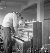 Lata 60., Kalisz, Polska.
Pracownik Fabryki Fortepianów i Pianin „Calisia” podczas pracy nad nowym pianinem.
Fot. Irena Jarosińska, zbiory Ośrodka KARTA