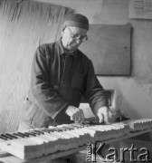 Lata 60., Kalisz, Polska.
Pracownik Fabryki Fortepianów i Pianin „Calisia” pracuje nad klawiaturą do nowego pianina.
Fot. Irena Jarosińska, zbiory Ośrodka KARTA