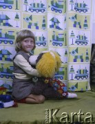 Lata 70. lub 80., Żyrardów, woj. warszawskie, Polska.
Dziewczynka o imieniu Irena pozuje do zdjęcia na tle zasłon wyprodukowanych w Żyrardowskich Zakładach Przemysłu Lniarskiego.
Fot. Irena Jarosińska, zbiory Ośrodka KARTA