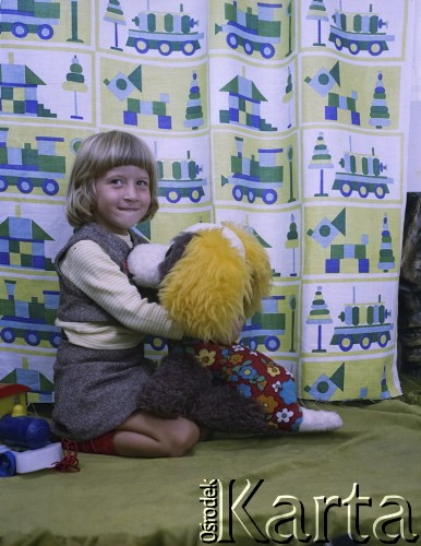 Lata 70. lub 80., Żyrardów, woj. warszawskie, Polska.
Dziewczynka o imieniu Irena pozuje do zdjęcia na tle zasłon wyprodukowanych w Żyrardowskich Zakładach Przemysłu Lniarskiego.
Fot. Irena Jarosińska, zbiory Ośrodka KARTA