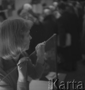 Lata 50., Warszawa, Polska.
Salon Cepelii przy ul. Rutkowskiego (obecnie Chmielna). Sprzedawczyni podczas pracy.
Fot. Irena Jarosińska, zbiory Ośrodka KARTA