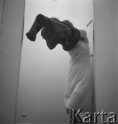 Lata 50., Warszawa, Polska.
Kobieta mierzy ubranie w przymierzalni w salonie Cepelii przy ul. Rutkowskiego (obecnie Chmielna). 
Fot. Irena Jarosińska, zbiory Ośrodka KARTA