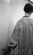 Lata 50., Warszawa, Polska.
Salon Cepelii przy ul. Rutkowskiego (obecnie Chmielna). Kobieta pozuje do zdjęcia w płaszczu.
Fot. Irena Jarosińska, zbiory Ośrodka KARTA 
