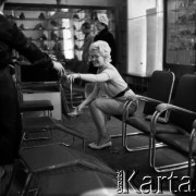 Lata 60., Warszawa, Polska.
Aktorka Bogusława Kożusznik podczas sesji zdjęciowej, n/z w sklepie obuwniczym.
Fot. Irena Jarosińska, zbiory Fundacji Ośrodka KARTA
