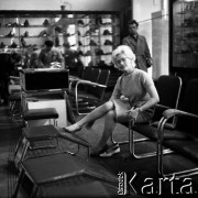 Lata 60., Warszawa, Polska.
Aktorka Bogusława Kożusznik podczas sesji zdjęciowej, n/z w sklepie obuwniczym.
Fot. Irena Jarosińska, zbiory Fundacji Ośrodka KARTA