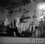 1961, Kadzidło, Polska.
Wnętrze chaty. Kobieta i dziecko. Ozdoby na ścianie - wycinanki kurpiowskie.
Fot. Irena Jarosińska, zbiory Ośrodka KARTA
