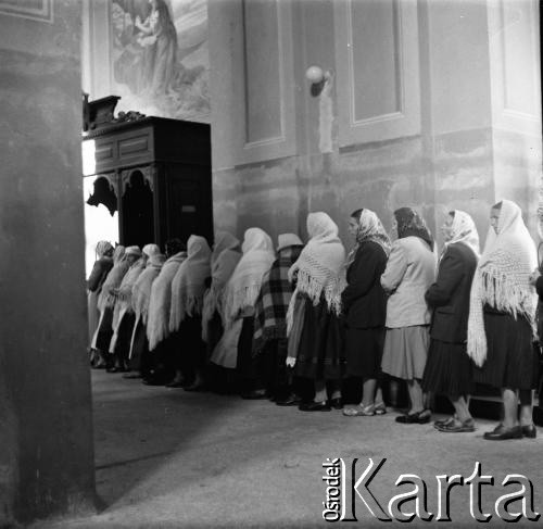 1961, Kadzidło, Polska.
Kościół pod wezwaniem Świętego Ducha - wnętrze. Kobiety w kolejce do konfesjonału.
Fot. Irena Jarosińska, zbiory Ośrodka KARTA
