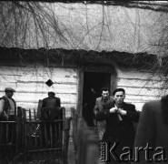 Lata 60., Bohoniki koło Sokółki, Polska.
Mężczyźni przy drewnianej chacie krytej strzechą.
Fot. Irena Jarosińska, zbiory Ośrodka KARTA