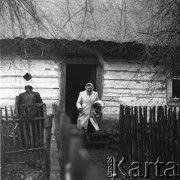 Lata 60., Bohoniki koło Sokółki, Polska.
Kobieta wychodząca z drewnianej chaty krytej strzechą.
Fot. Irena Jarosińska, zbiory Ośrodka KARTA