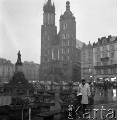 1975-1977, Kraków, Polska.
Doktorant Instytutu Technologii i Mechanizacji Odlewnictwa Akademii Górniczo-Hutniczej Sarat Chandra Panigrahi z Indii podczas spaceru po Rynku Głównym. W tle widoczna Bazylika Mariacka. 
Fot. Irena Jarosińska, zbiory Ośrodka KARTA