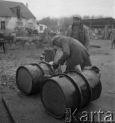 Lata 50. lub 60., woj. białostockie, Polska.
Wieś. Mężczyzna przelewa benzynę z beczki do kanistra.
Fot. Irena Jarosińska, zbiory Ośrodka KARTA