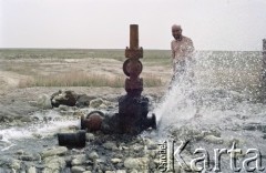 1992, Kabul, prowincja Kabul, Afganistan.
Konwój podczas postoju w obozowisku. Na zdjęciu mężczyzna bierze kąpiel korzystając z zaimprowizowanego natrysku przy hydrancie. 
Fot. Irena Jarosińska, zbiory Ośrodka KARTA
