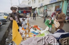 1992, Kabul, prowincja Kabul, Afganistan.
Sprzedawca tkanin na ulicznym stoisku prezentuje swój asortyment.
Fot. Irena Jarosińska, zbiory Ośrodka KARTA