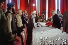 1992, Kabul, prowincja Kabul, Afganistan.
Konferencja prasowa afgańskiego polityka i przywódcy Sibghatullaha Modżaddediego (w białym turbanie). Od 28 kwietnia do 28 czerwca 1992 Modżaddedi pełnił funkcję tymczasowego prezydenta Afganistanu. Objął urząd po wycofaniu się wojsk radzieckich z Afganistanu, wkroczeniu  mudżahedinów do Kabulu i upadku wspieranych przez Sowietów komunistycznych rządów prezydenta Mohammada Nadżibullaha. Na zdjęciu Modżaddedi w rozmowie z Andrzejem Wawrzyniakiem, który w latach 1990-1993 pełnił urząd chargé d’affaires Rzeczpospolitej Polskiej w Afganistanie.
Fot. Irena Jarosińska, zbiory Ośrodka KARTA