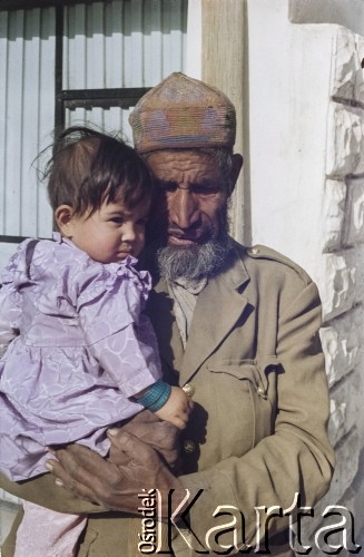1992, Kabul, prowincja Kabul, Afganistan.
Mężczyzna ubrany w stary wojskowy mundur trzyma na rękach dziewczynkę.
Fot. Irena Jarosińska, zbiory Ośrodka KARTA