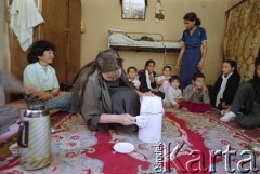 1992, Kabul, prowincja Kabul, Afganistan.
Spotkanie przy herbacie w afgańskim domu. Na zdjęciu młoda kobieta rozlewa napój do filiżanek. Wokół niej na podłodze siedzą zgromadzeni goście.
Fot. Irena Jarosińska, zbiory Ośrodka KARTA