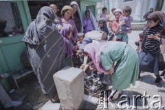 1992, Kabul, prowinacja Kabul, Afganistan.
Grupa kobiet i dzieci nieopodal meczetu Shah-Do Shamshira (Meczet Króla Dwóch Mieczy), świątyni wzniesionej w 1920 roku za panowania króla Amanullaha. Kobiety obmywają twarze wodą z ulicznego kraniku.
Fot. Irena Jarosińska, zbiory Ośrodka KARTA