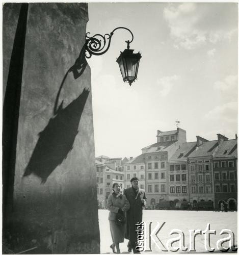 Lata 50., Warszawa, Polska.
Mężczyzna i kobieta spacerują po Rynku Starego Miasta.
Fot. Irena Jarosińska, zbiory Ośrodka KARTA.