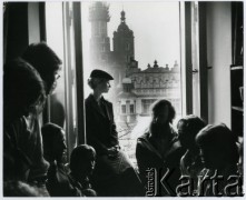 Brak daty, Kraków, Polska.
Grupa osób w pomieszczeniu, w oknie widoczny fragment Sukiennic i wieże kościoła Mariackiego.
Fot. Irena Jarosińska, zbiory Ośrodka KARTA