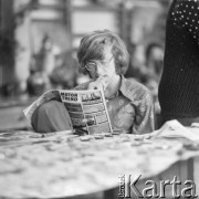 1974, Warszawa, Polska.
Wystawa hobbystów i zbieraczy w IV Liceum Ogólnokształcącym im. Adama Mickiewicza. Na zdjęciu uczeń siedzący przy stoisku z brelokami czyta gazetę 