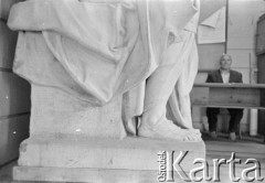 Lata 60., Warszawa, Polska.
Fragment rzeźby w pracownia na Wydziale Rzeźby Akademii Sztuk Pięknych. W głębi za biurkiem siedzi mężczyzna.
Fot. Irena Jarosińska, zbiory Ośrodka KARTA
