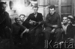 Wiosna 1944, Wierzbałowo (Virbalis), Litwa.
Chłopcy wywiezieni w kwietniu 1943 z okolic Wilna do pracy przymusowej na dużej przygranicznej stacji kolejowej w Kybartach (Kybartai). Stacja nosiła nazwę starszej od miasteczka Kybarty wsi Wierzbałowo odległej o 5 km. Wnętrze dwuosobowego pokoju w nowym baraku zamieszkałym wyłącznie przez Polaków, od lewej: Sienkiewicz, Rajmund Chmielewski, Romuald Żawronek, Wacław Zdanowicz z mandoliną, Michał Janowicz, Kazimierz Żawronek i Dominik Poczepowicz.
Fot. Czesław Zapolski, zbiory Ośrodka KARTA, udostępnił Michał Janowicz.