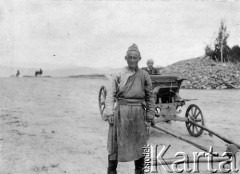 1913, Mongolia.
Mongolski chłopak towarzyszący wyprawie, za nim powóz, w którym siedzi Zdzisław Poklewski-Koziełł. 
Zdjęcie pochodzi z albumu z podróży Zdzisława i Konstancji Poklewskich-Koziełł, Janusza i Natalii Łosiów oraz Stanisława i Julii Rosenwerthów do Mongolii w 1913 roku. 
Fot. Zdzisław Poklewski-Koziełł, zbiory Ośrodka KARTA, przekazała Hanna Kunachowicz